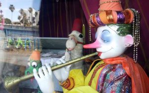 A marionette doll holding a flute