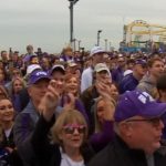 TCU fans donning purple crowd the Santa Monica Pier for a pep rally before the National College Football Championship game in Los Angeles