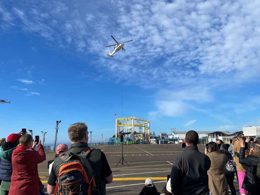 A helicopter hovers above the Santa Monica Pier prepared to lift the Sea Dragon ride off to retirement - Photo by Pacific Park