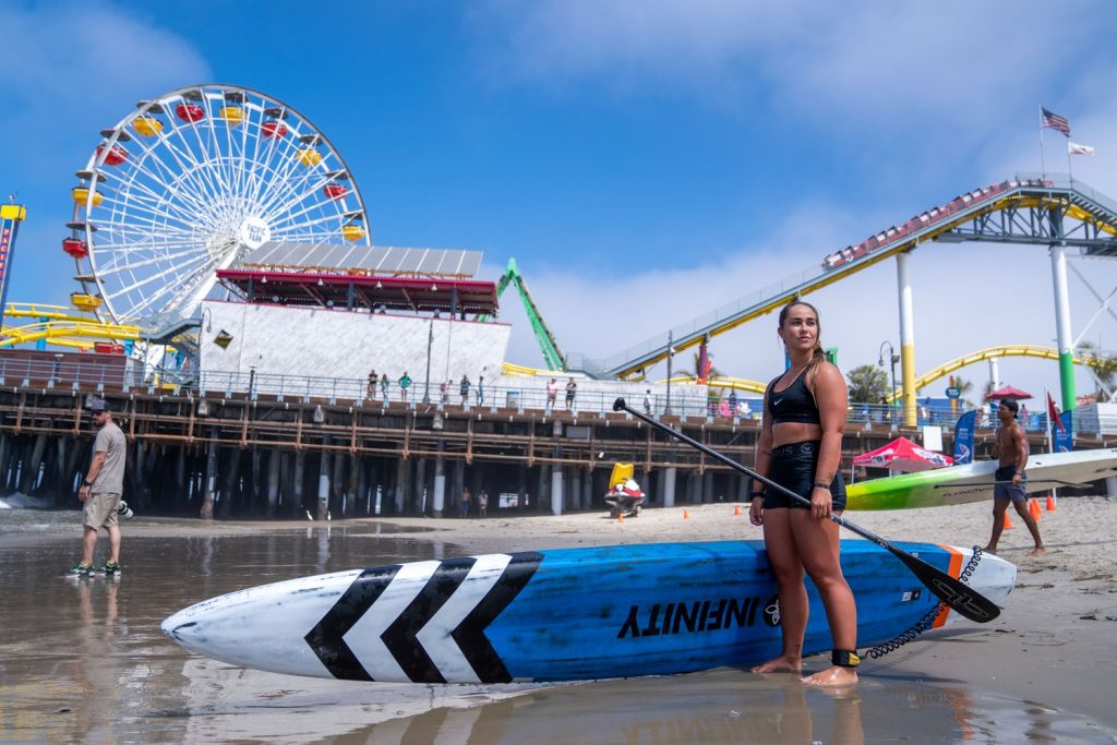 A stand up paddle boarder preparing to compete in the Pier360 Paddle board race at the Santa Monica Pier.