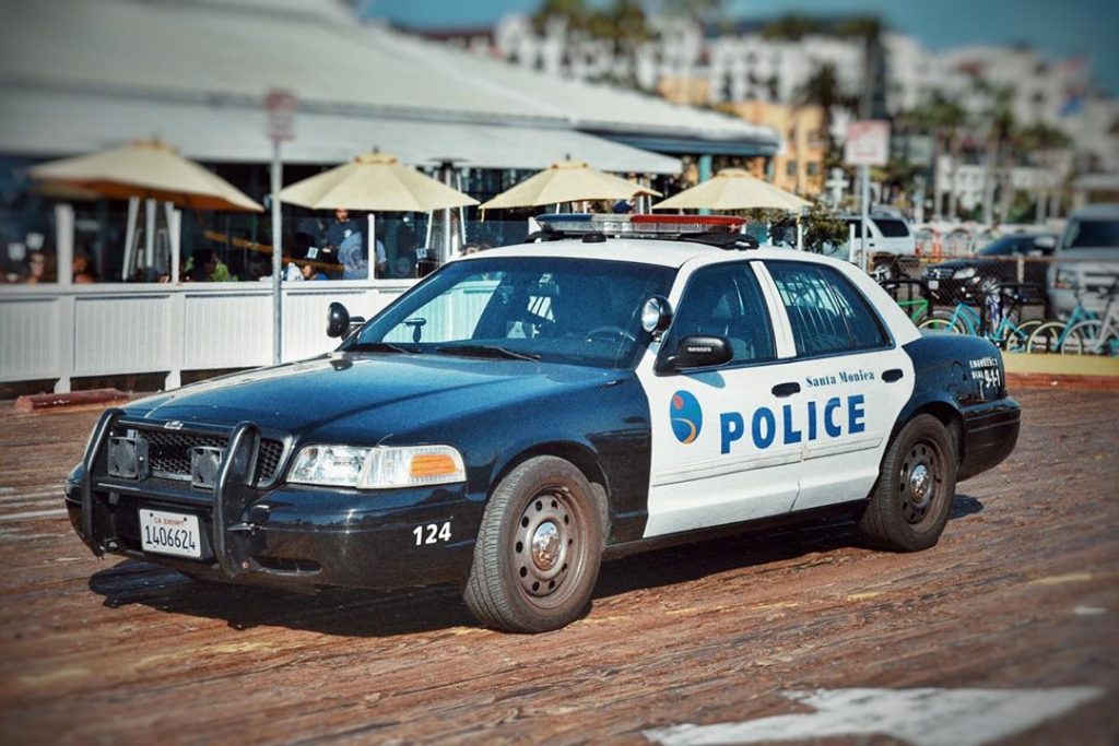 A black-and-white Santa Monica Police cruiser parked on the boardwalk of the Santa Monica Pier