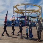 Cadets march on the Santa Monica Pier holding flags for Veterans' Day